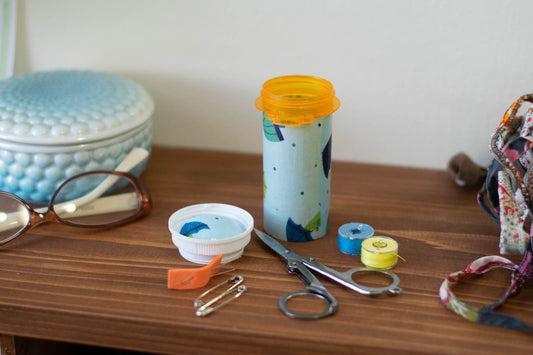 upcycled prescription bottle sewing kit — umbrella kids on blue, 4" high, open with contents