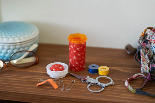 upcycled prescription bottle sewing kit — white sparkles on red, 3" high, open with contents