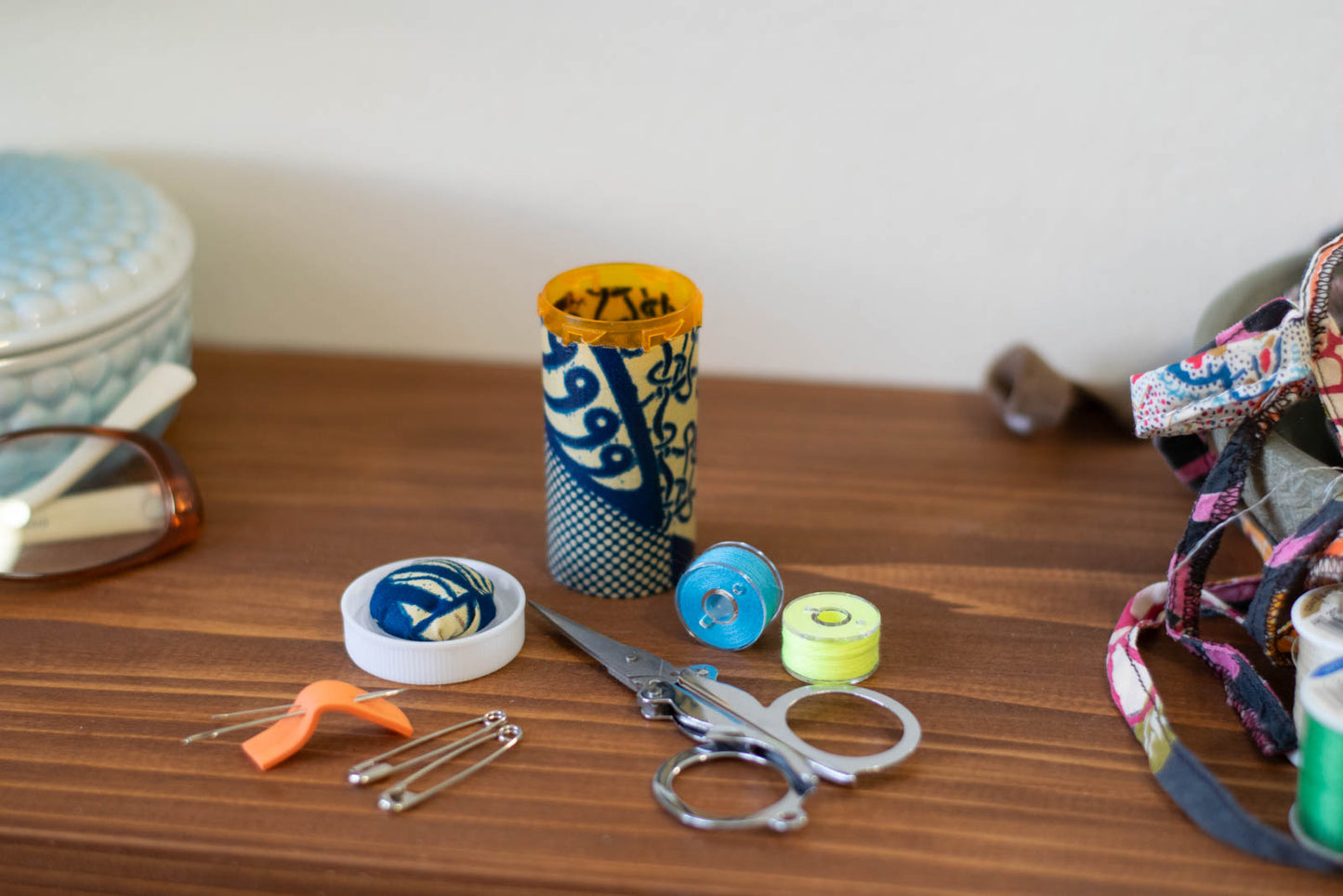 upcyclced prescription bottle sewing kit — blue African wax print, 2.75" high, open with contents