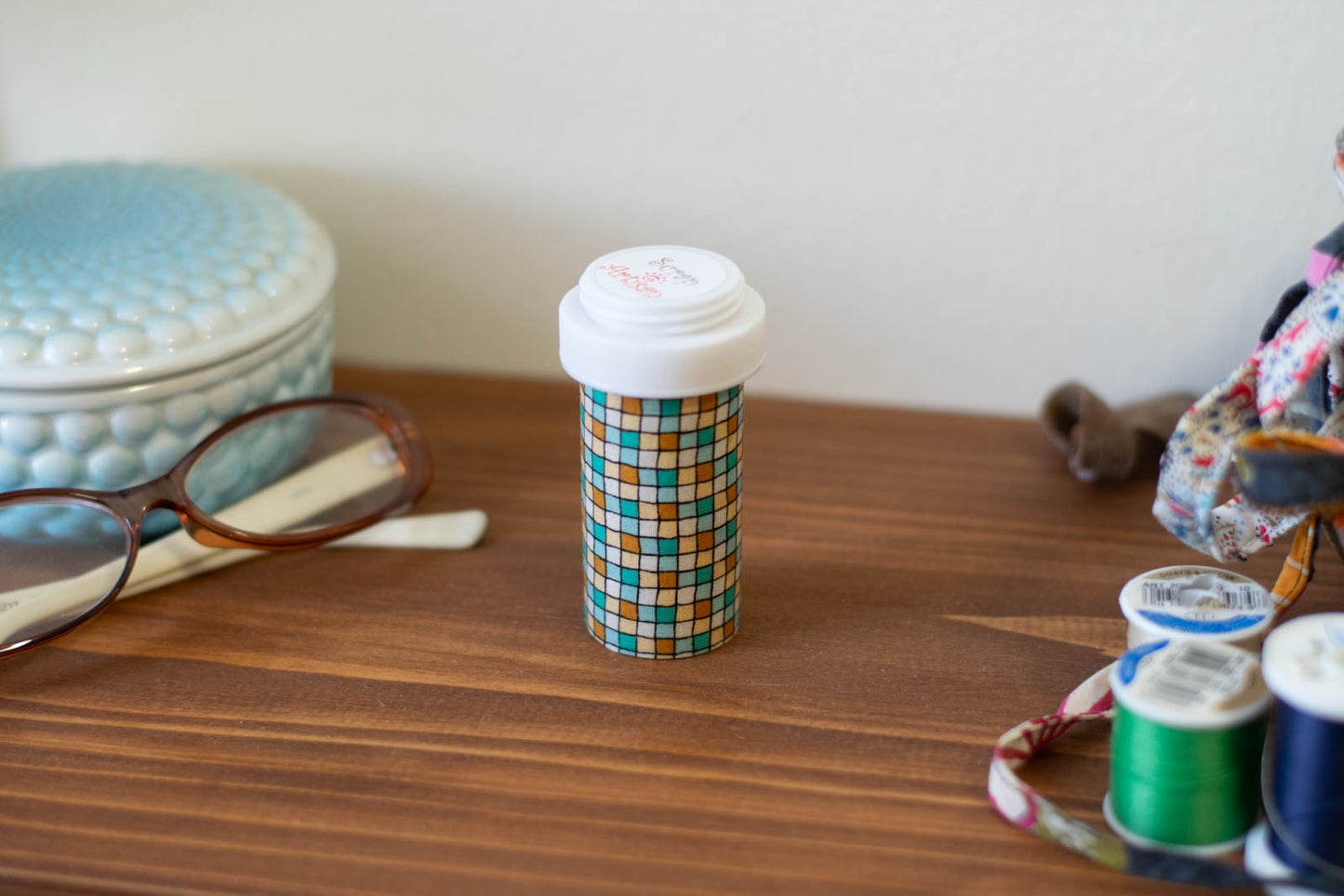 upcycled prescription bottle sewing kit — green and ochre tiles, closed, 3.25" high