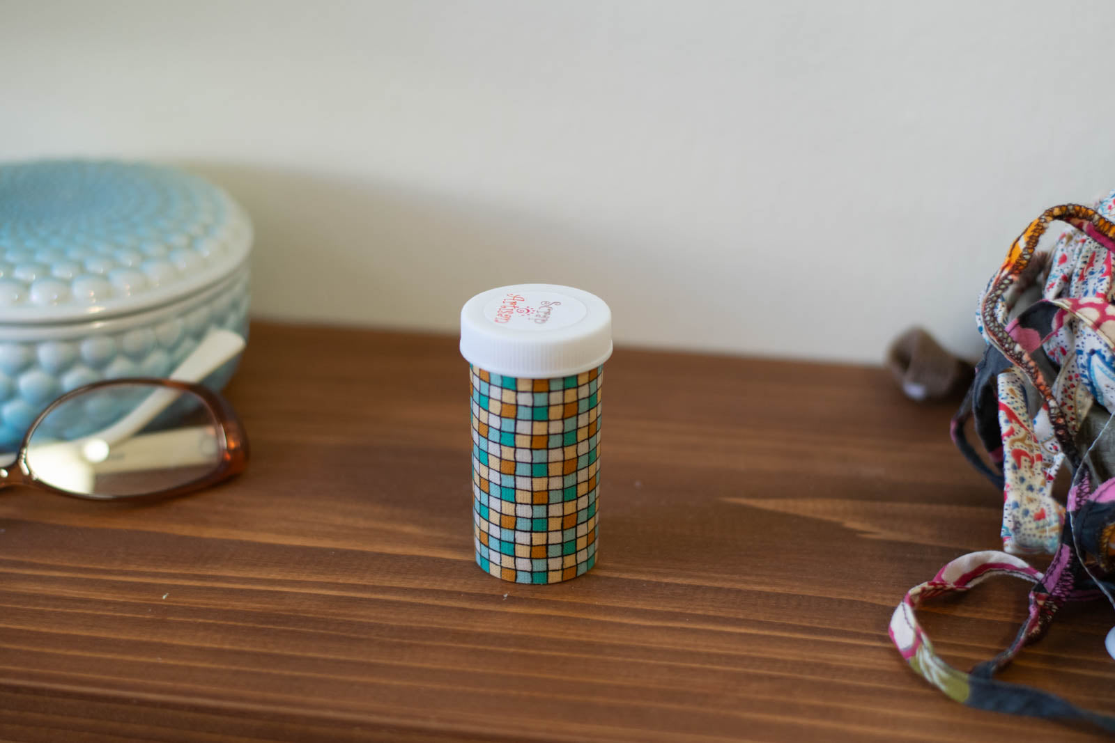 upcycled prescription bottle sewing kit — green and ochre tiles, closed, 2.75" high